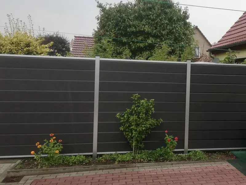 Anthrazitfarbener Sichtschutzzaun mit waagerechten Paneelen und silbernen Pfosten in einem Garten